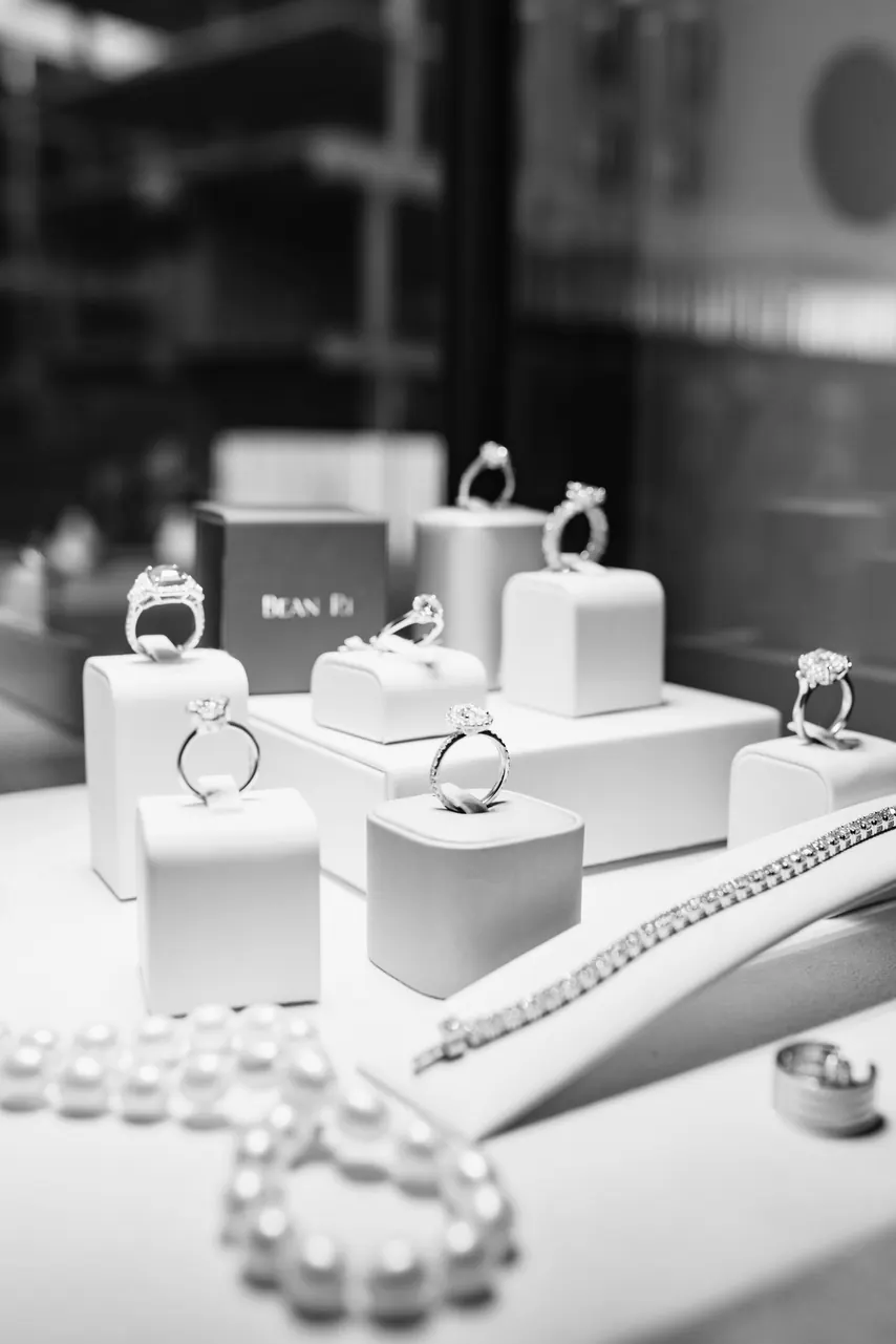 Bean Ri rings on white plinths in a lit display case at KOOS
