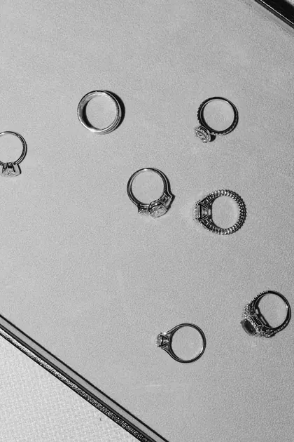 Bean Ri rings scattered on a pale surface, in black and white
